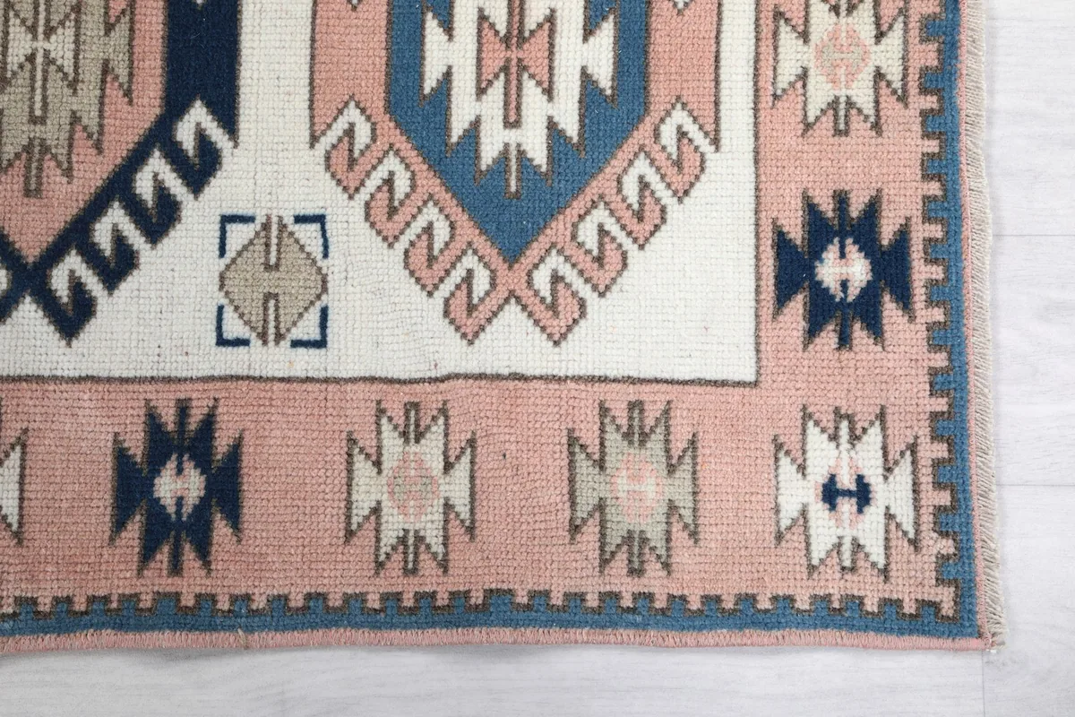 Detailed view of the rose border and corner geometric motifs of the rug