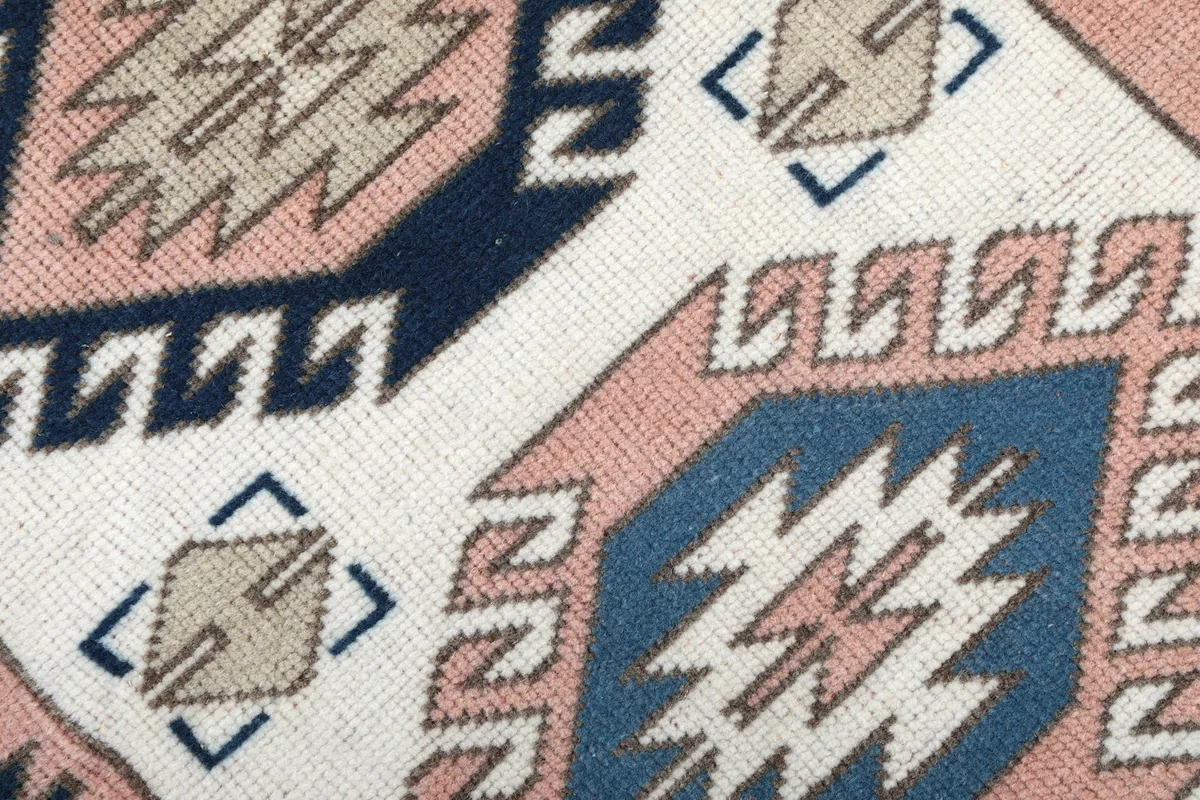 Texture of the low wool pile, showing the hand-knotted details and colors