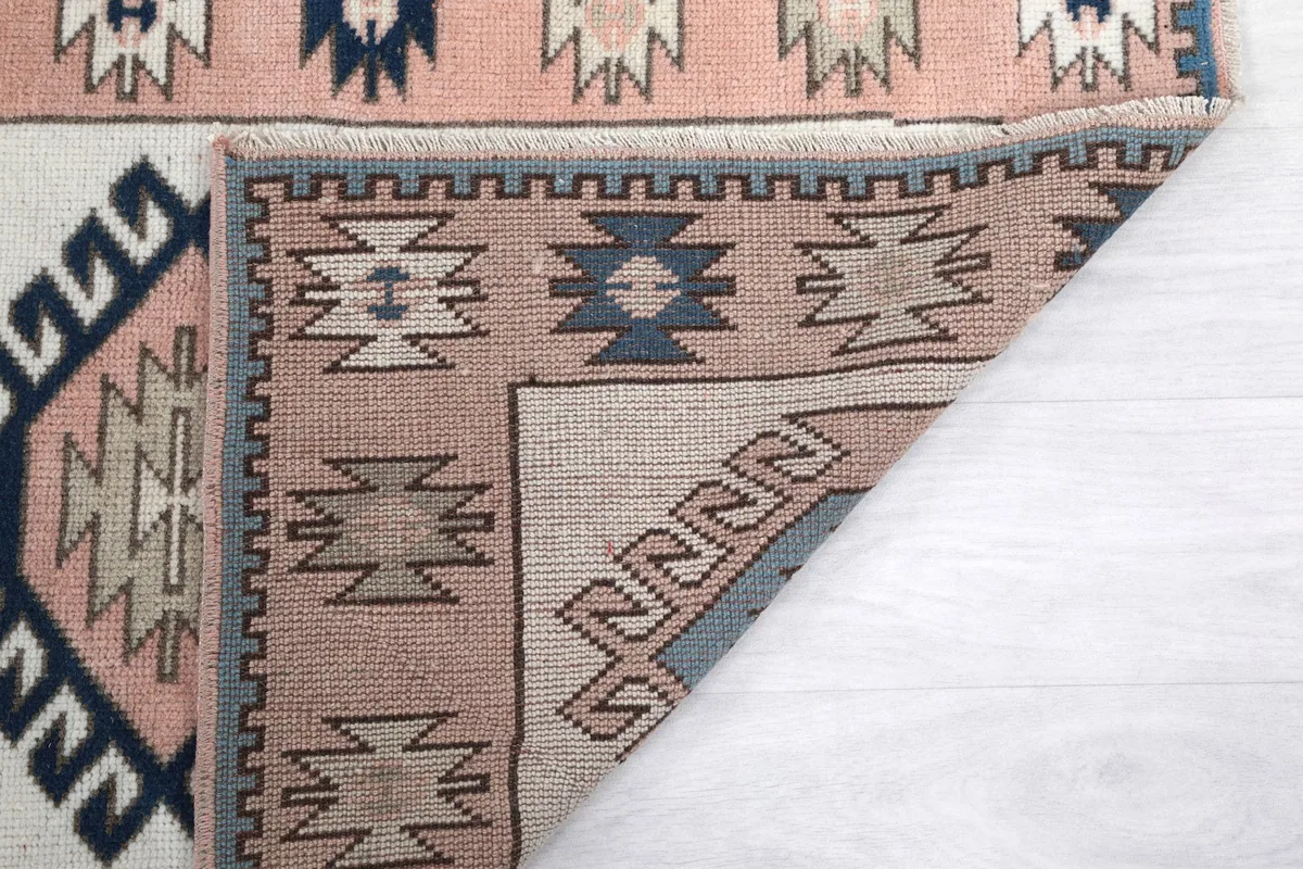 Another view of the rug's folded corner, displaying the back of the weave