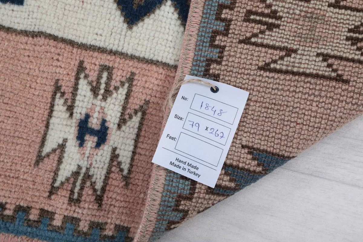 Tag showing the rug's dimensions and origin, attached to the back of the rug