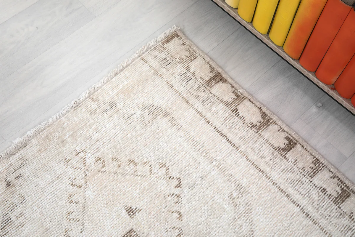 Corner detail of the Cream Tribal Medallion Rug, showing the geometric border pattern and fringe