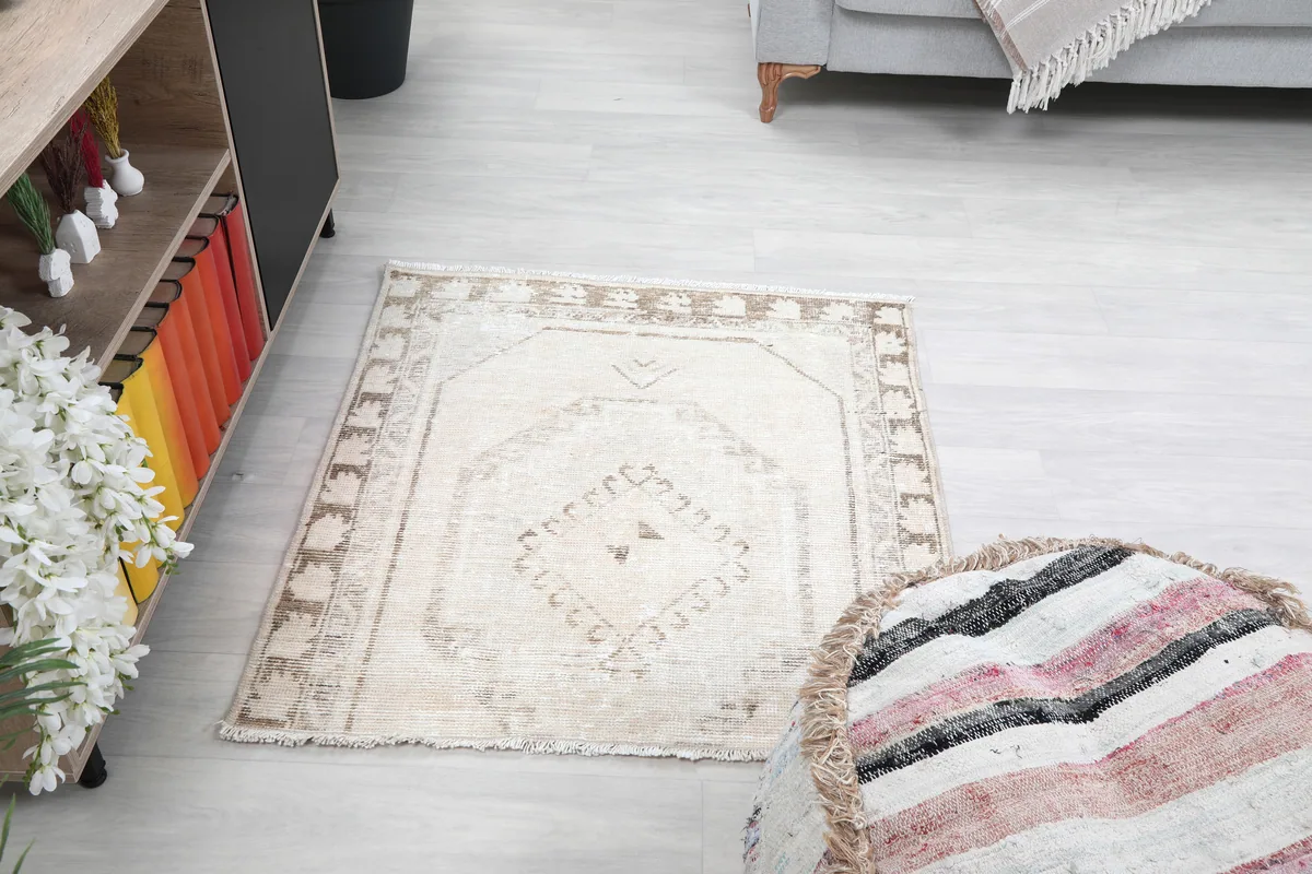 Cream Tribal Medallion Rug in a room with a pouf and cabinet, showing its placement and overall look