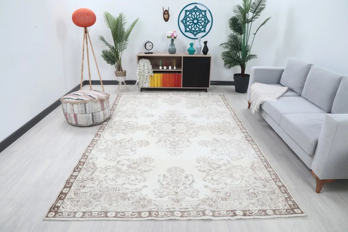 Ivory and brown vintage rug displayed in a bright living room setting with a sofa