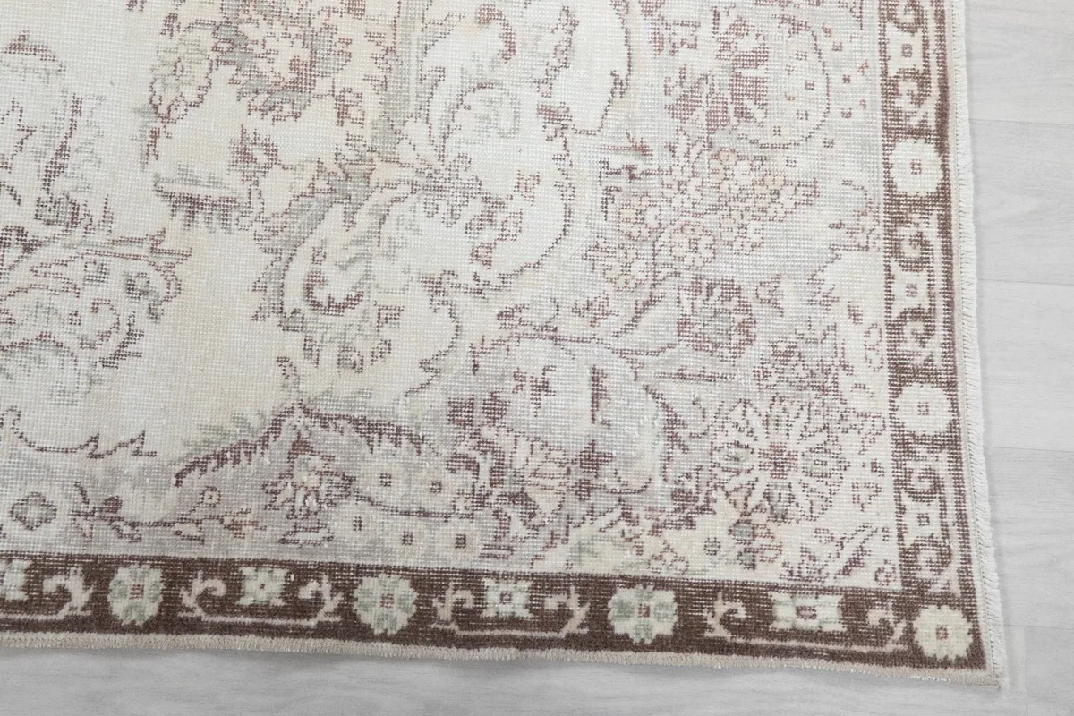 Detailed view of the brown border with geometric motifs and a corner of the rug