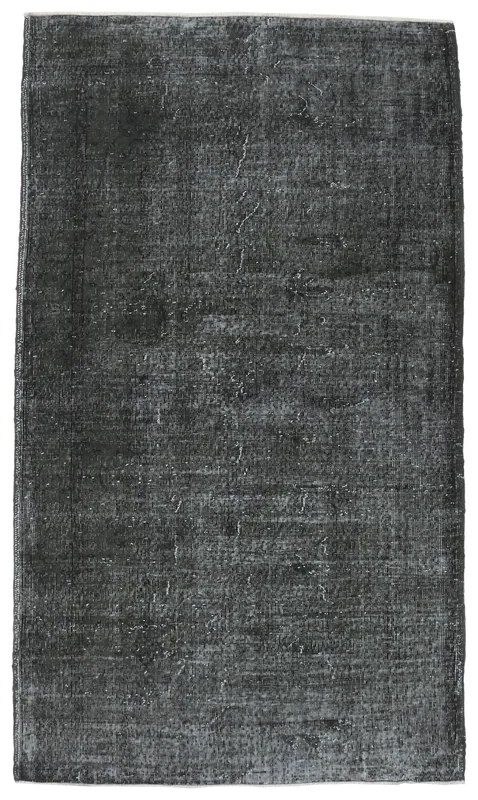 Full overhead view of a charcoal vintage Anatolian area rug with faded appearance.