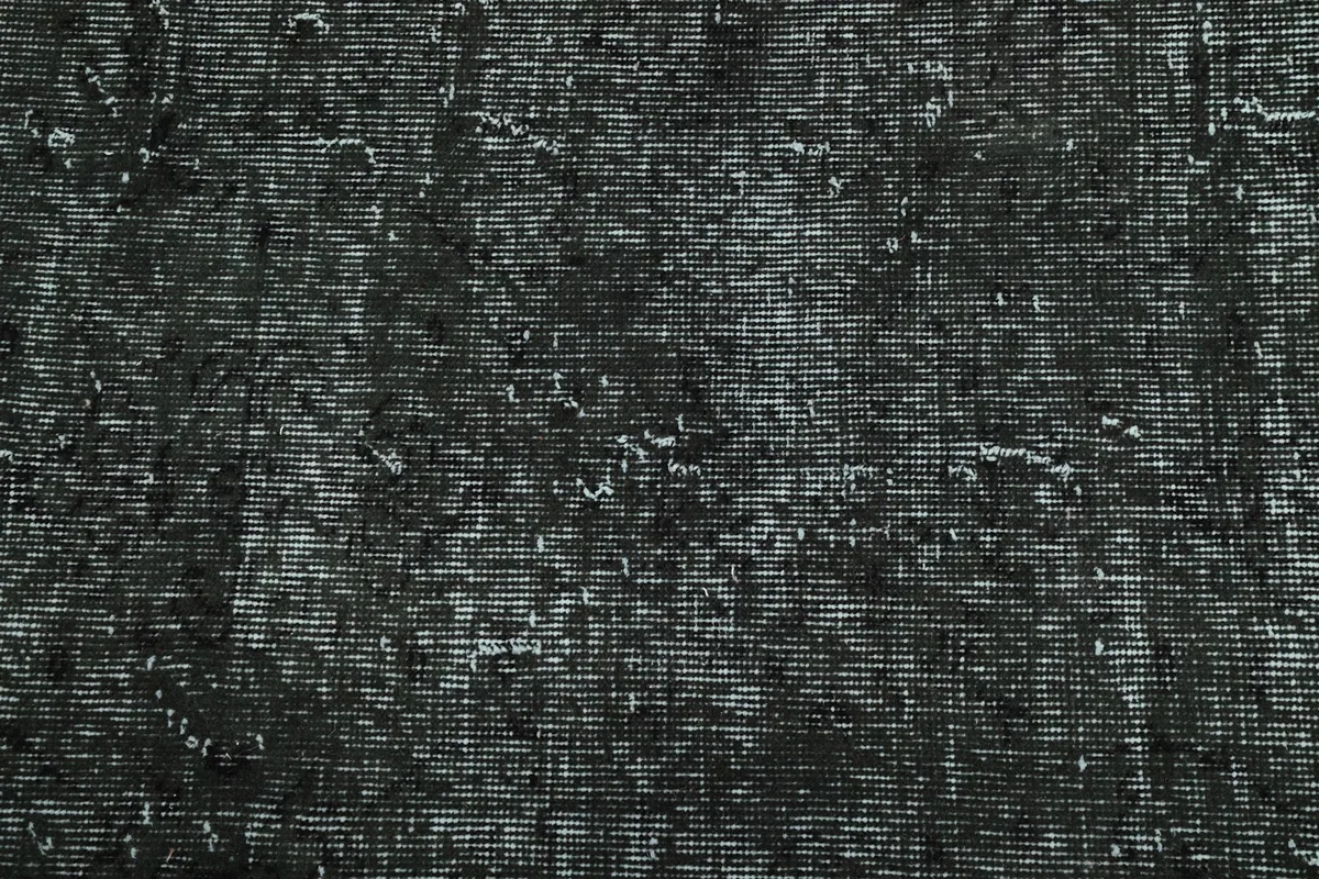 Close-up detail of the rug's distressed pile, showing individual knots and faded wool fibers.
