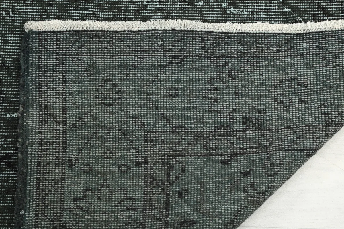 Close-up of the rug's back, showing the tight hand-knotting on the cotton foundation.