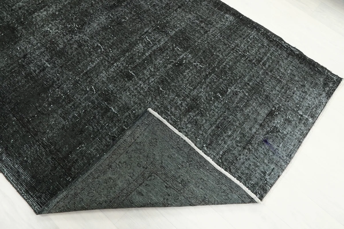 The rug folded back to reveal its cotton foundation and the reverse side of the hand-knotted construction.