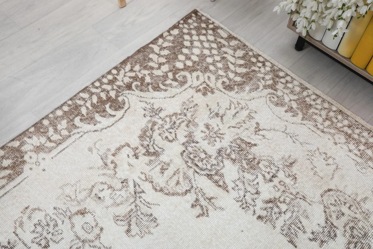 Corner view highlighting the detailed beige border and ivory field