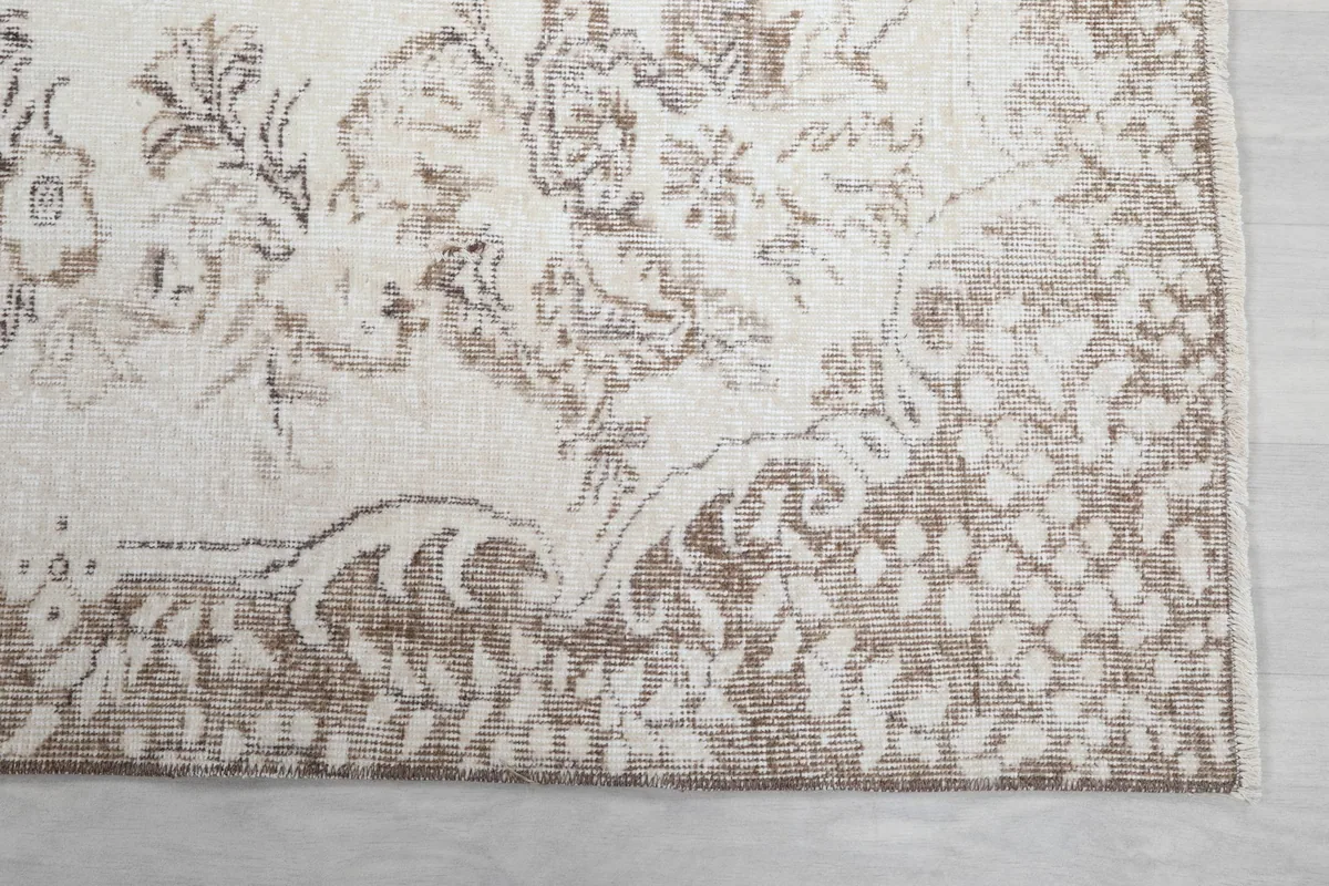 Detail of the beige border design and corner of the vintage rug