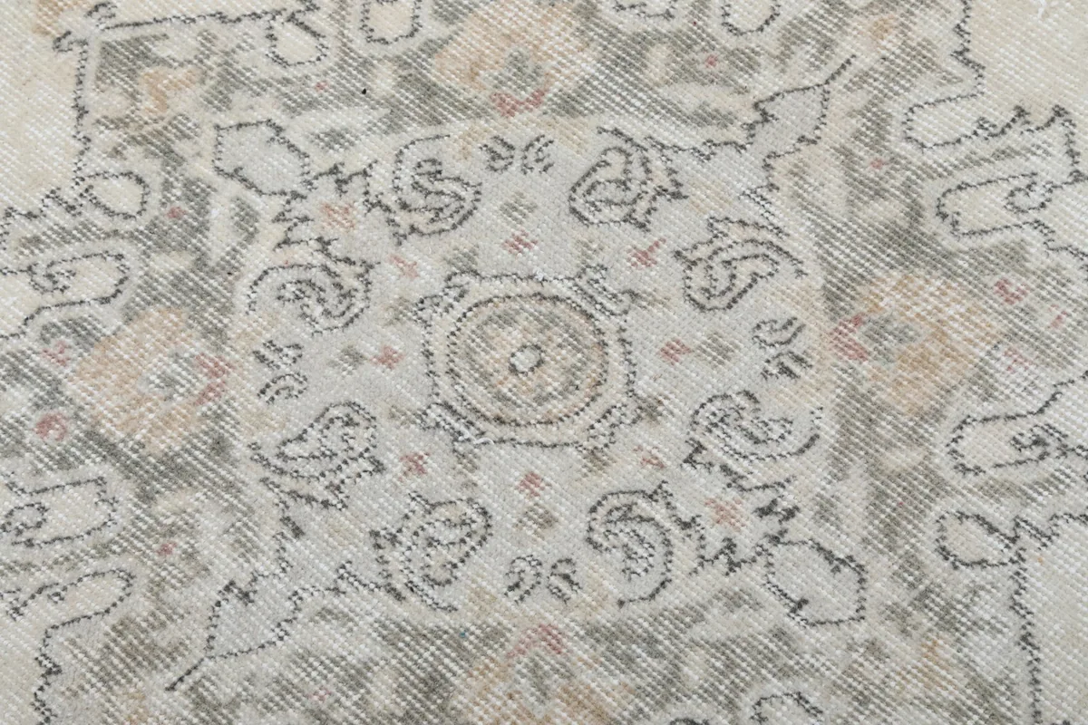 Close-up of the intricate gray and tan motifs within the medallion