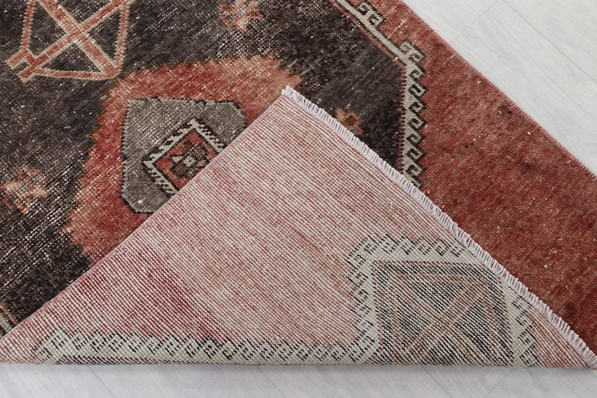 Corner of the rug folded back to show the cotton foundation and hand-knotted construction
