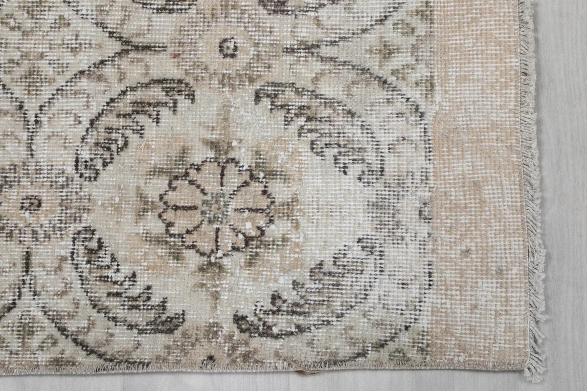 Detail shot of the rug's corner, showing the floral motif and fringe