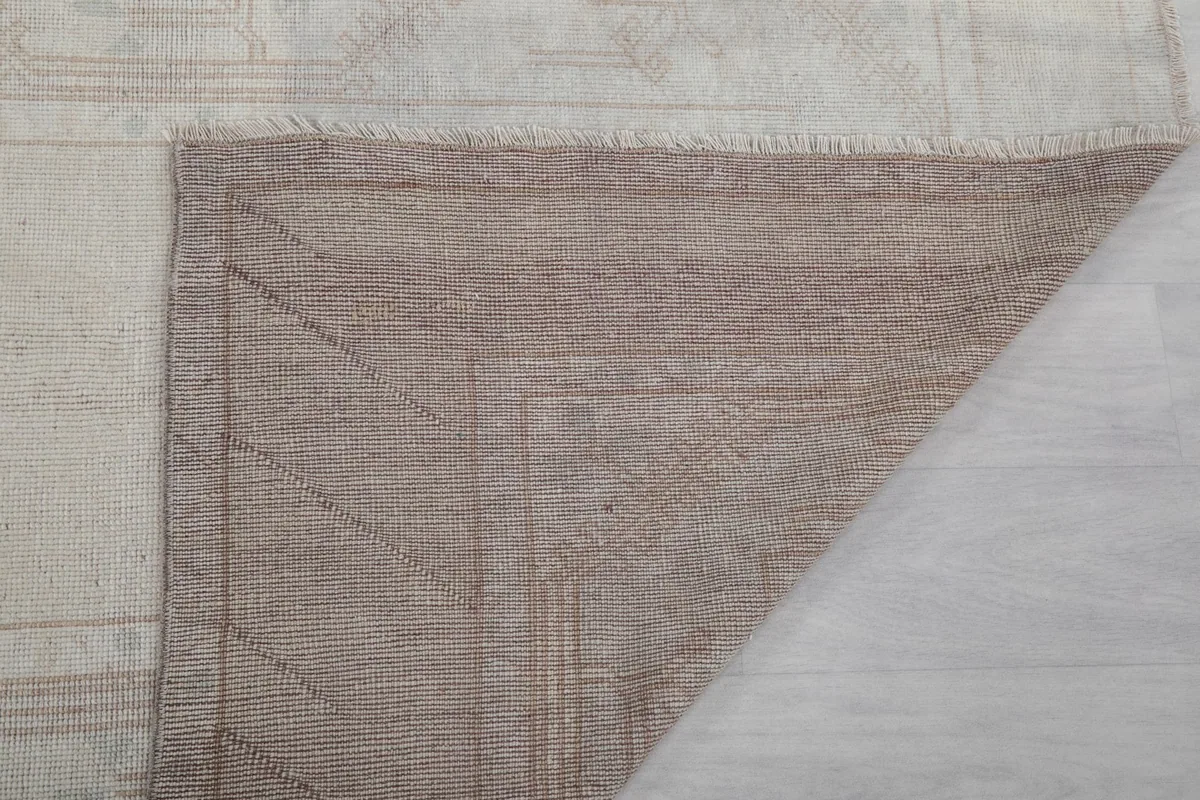 Close-up of the rug's reverse side, revealing the tight knotting of the cotton foundation.