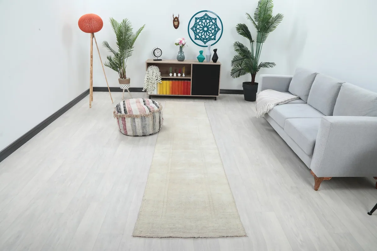 Ivory runner rug in a modern living room setting, viewed from a wide angle.