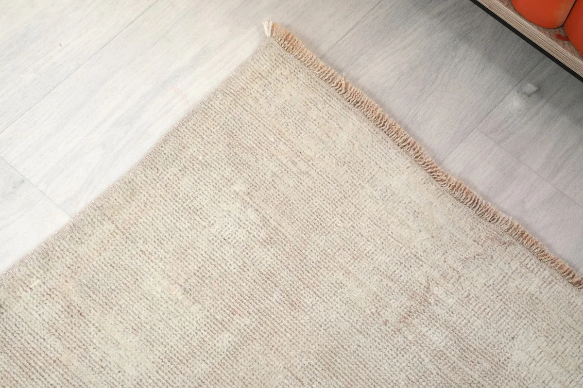 Detail of the rug's edge and subtle fringe, showing the hand-finished quality.