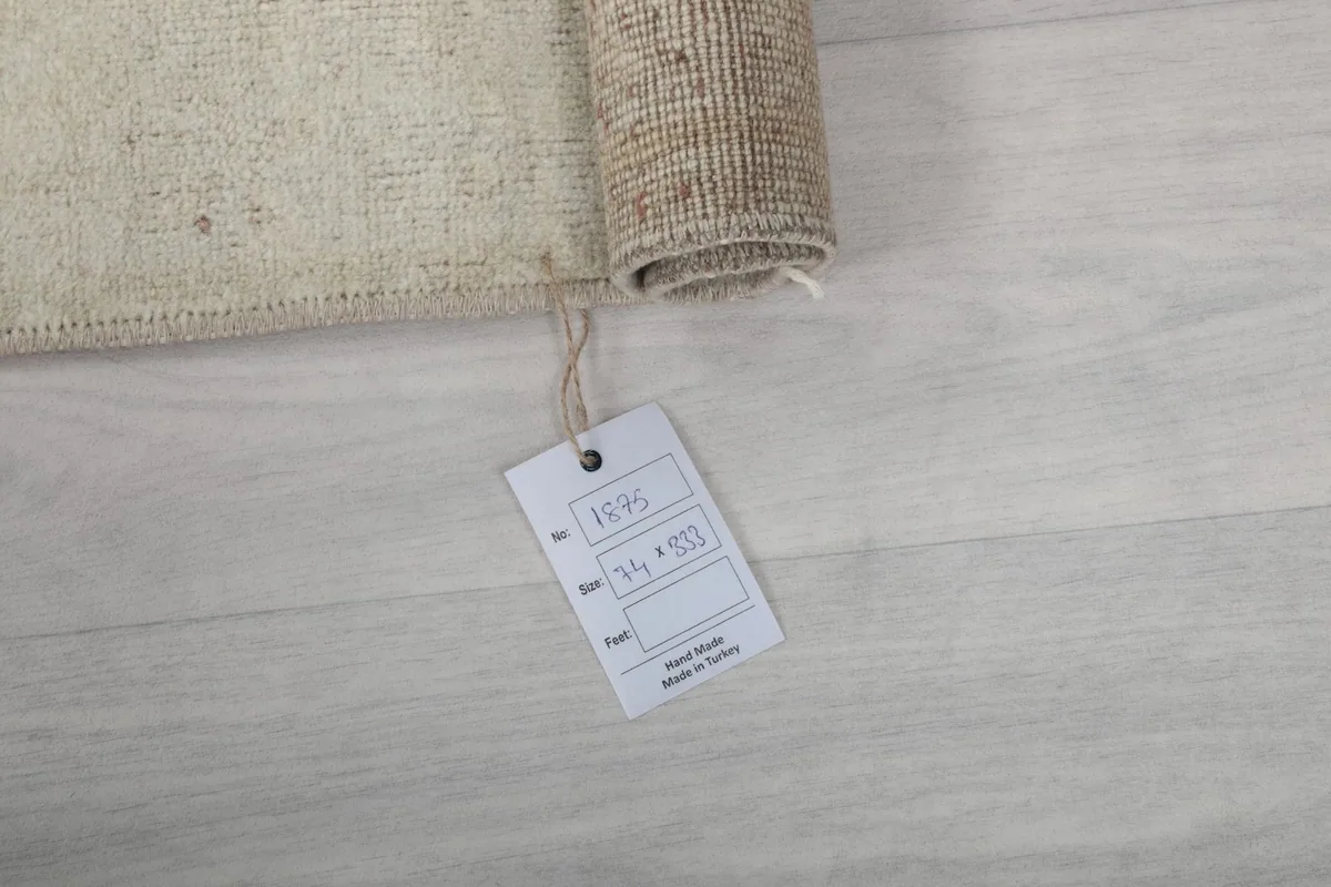 Rolled corner of the rug with the product tag showing size and origin details.