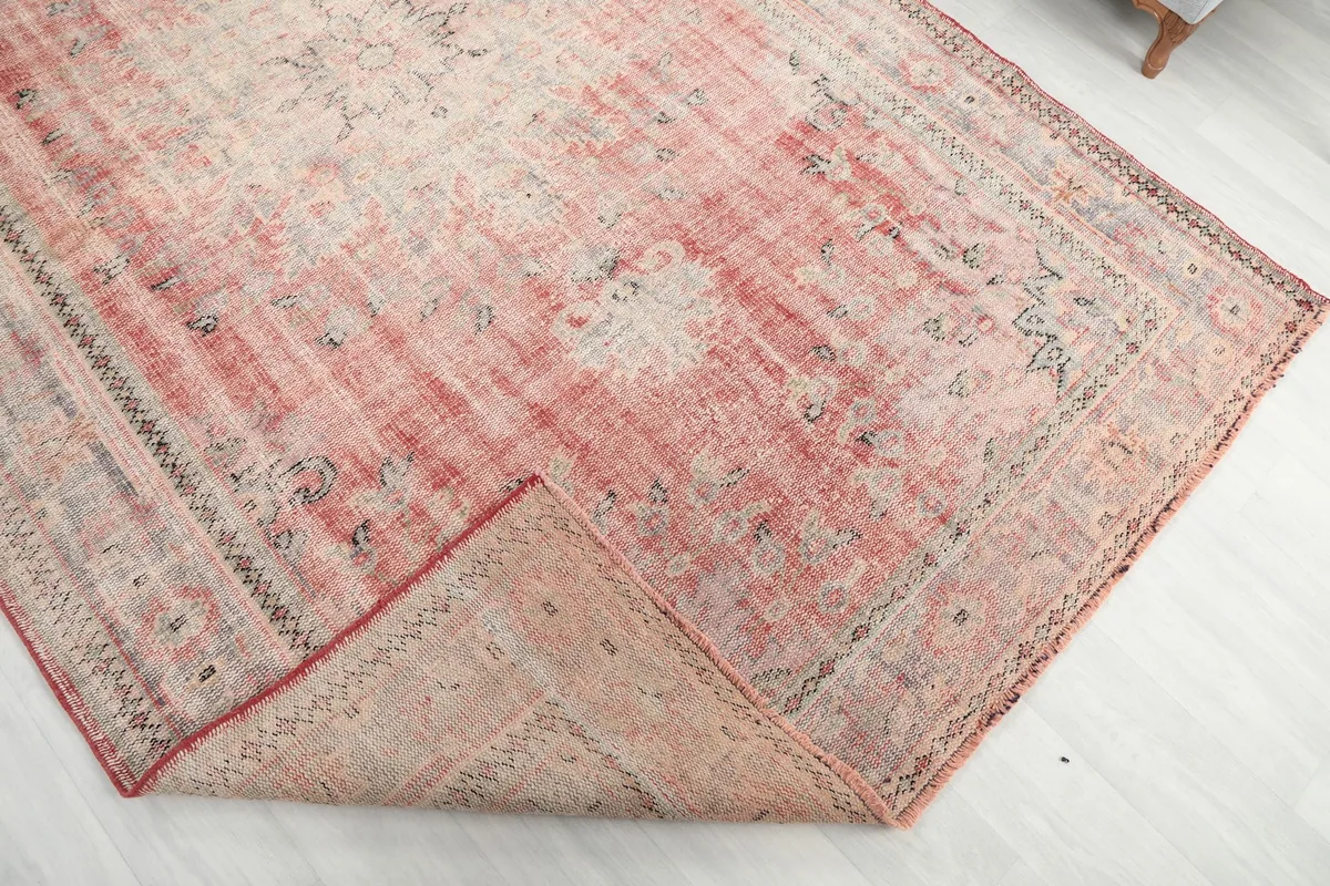 Corner of the rug folded back to reveal the back of the hand-knotted wool pile