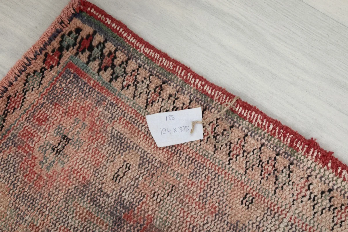 Label showing the dimensions 194 x 308 cm attached to the back of the rug