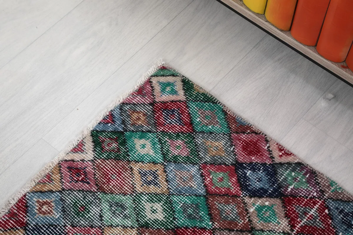 Corner view of the rug, showcasing the intricate diamond pattern and fringe detail