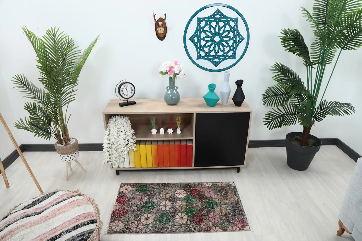 Multicolor floral area rug placed in a modern living space with plants and a wooden console