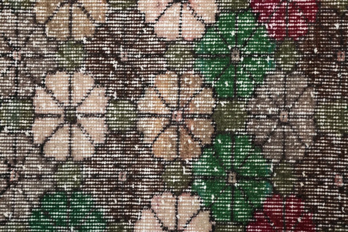 Overhead close-up of the hand-knotted wool pile and intricate floral design