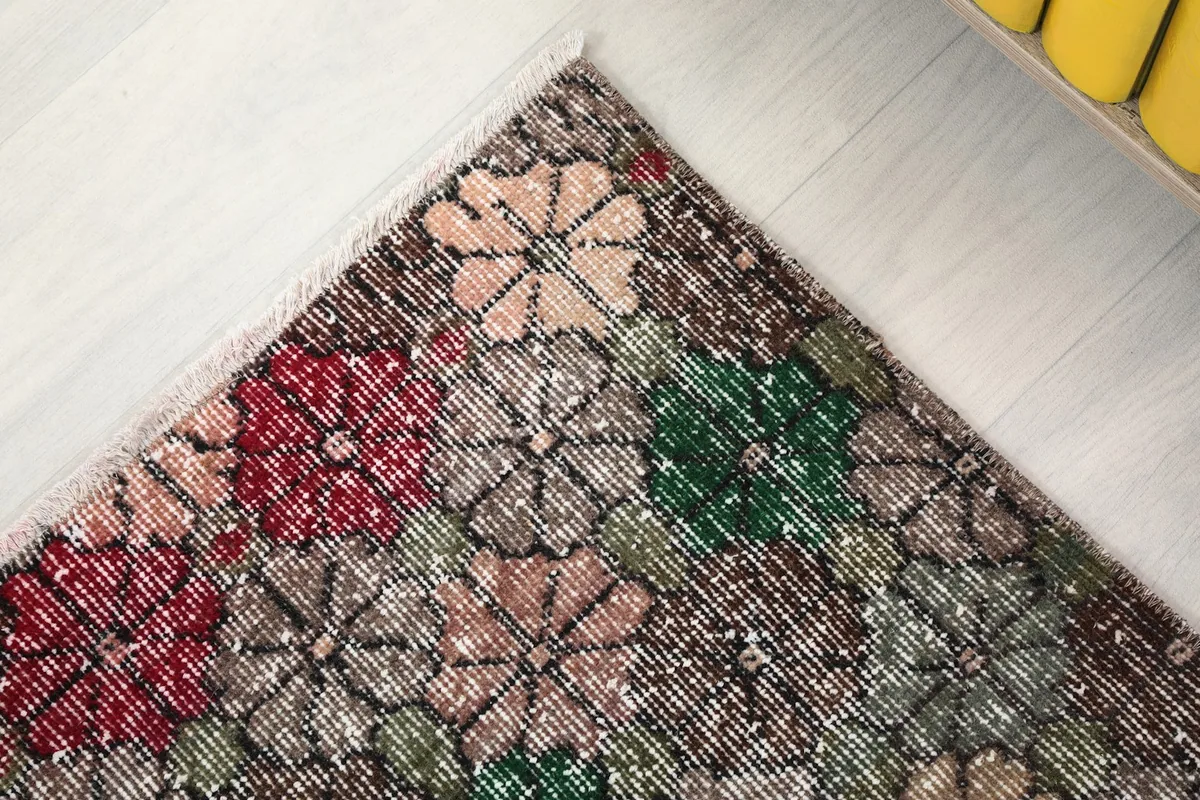 Corner detail of the rug, showing the fringe and the transition of colors