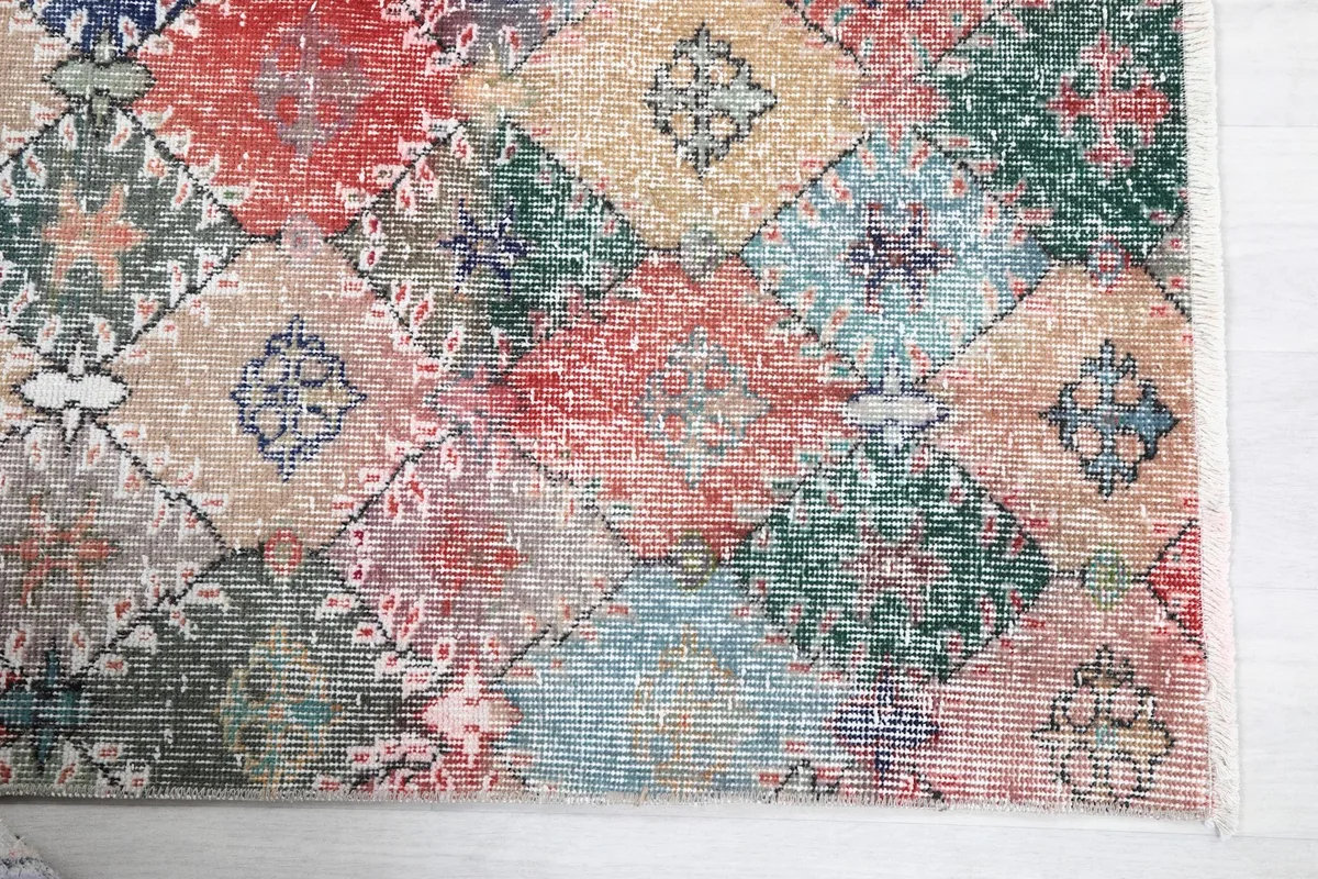 Detailed view of the rug's surface, showing individual patchwork squares and their varied colors and motifs