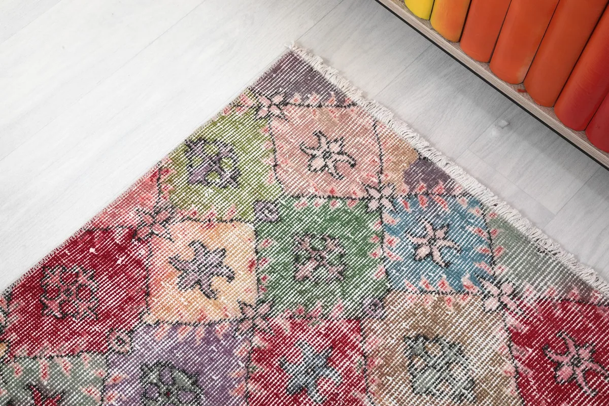 Corner detail of the multicolor runner, showing the intricate floral motifs within the geometric squares