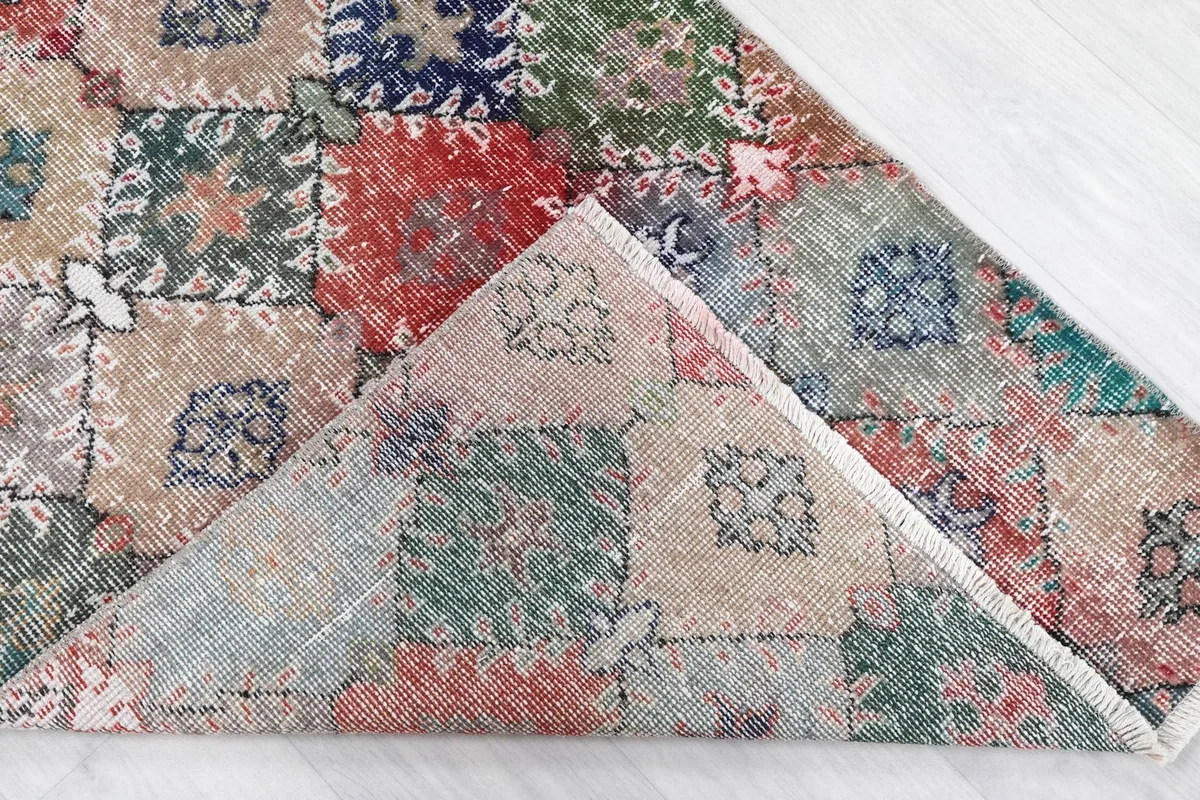 Folded corner showing the back of the hand-knotted wool rug, revealing the cotton foundation