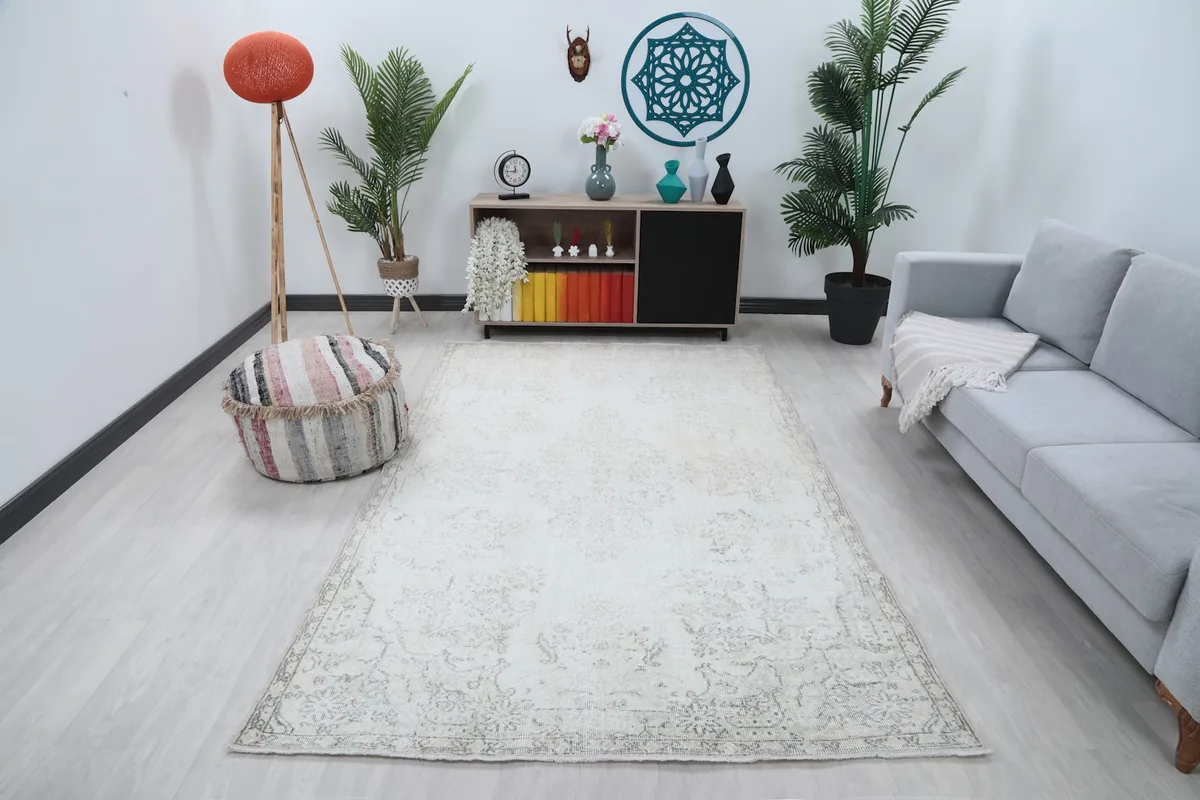 Cream and gray vintage Anatolian rug in a modern living room setting with a gray sofa