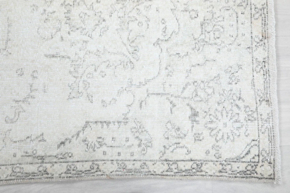 Detailed view of the faded floral and geometric motifs and the subtle gray border