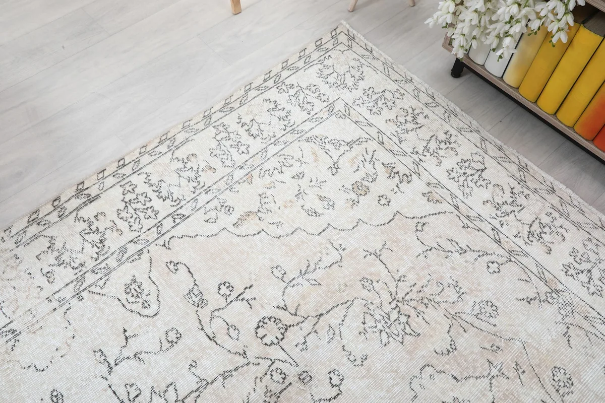 Corner view of the rug, illustrating the border pattern and the gentle color variations in the pile.