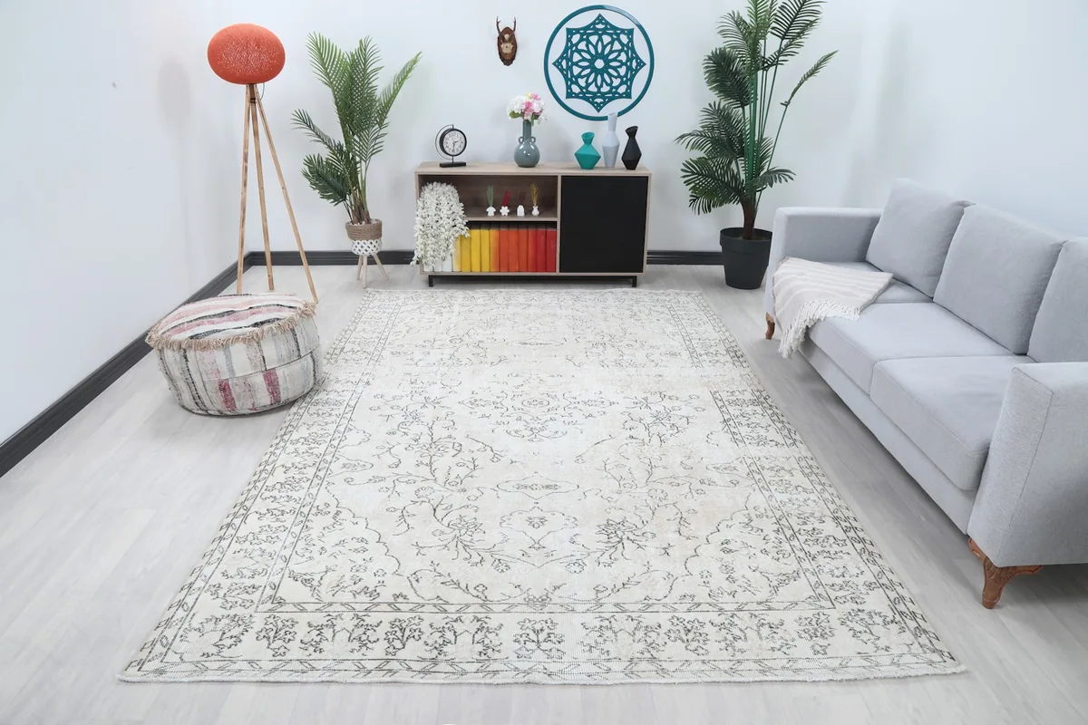 Vintage ivory and charcoal rug displayed in a bright living room setting with a sofa and decor.