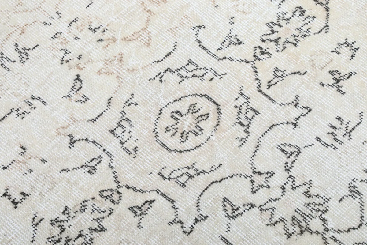 Detailed view of the hand-knotted wool pile, showing individual knots and the distressed appearance.