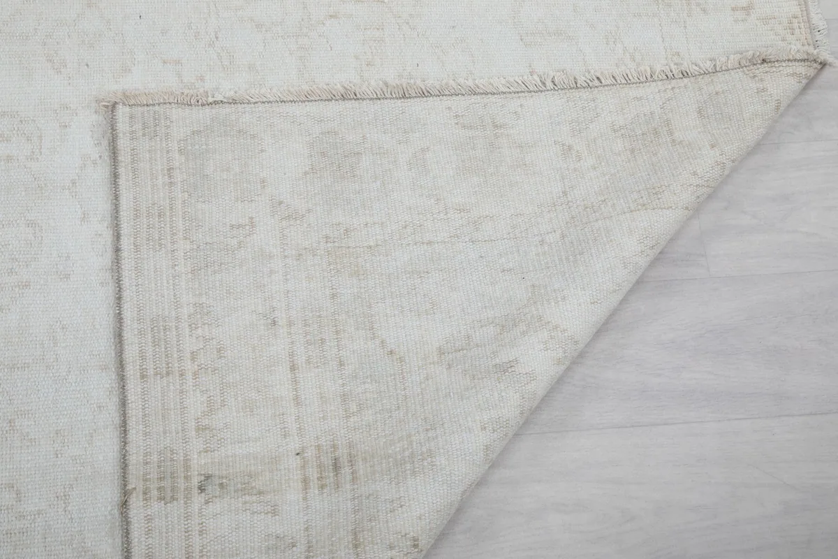 Underside of the rug showing the reverse of the hand-knotted wool pile and cotton foundation