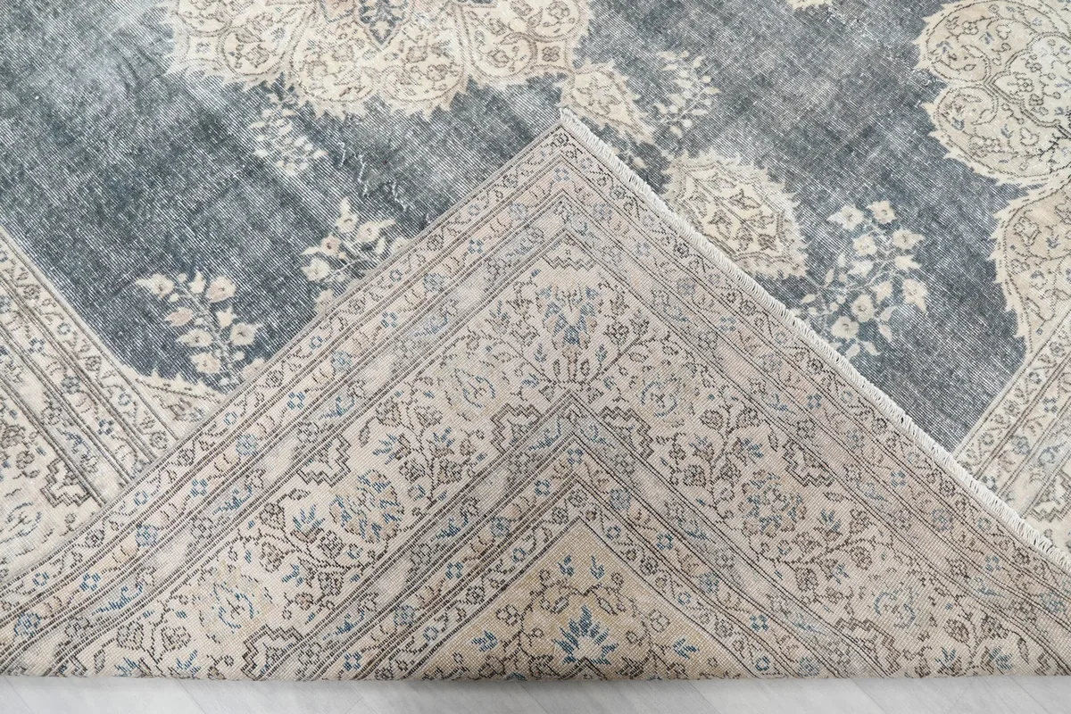 View of the rug's reverse side, revealing the hand-knotted cotton foundation and the back of the wool pile.