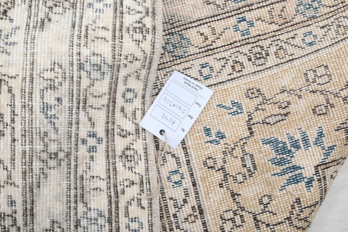 Detail of the rug's construction and a small tag, showing the quality of the hand-knotted wool and cotton.