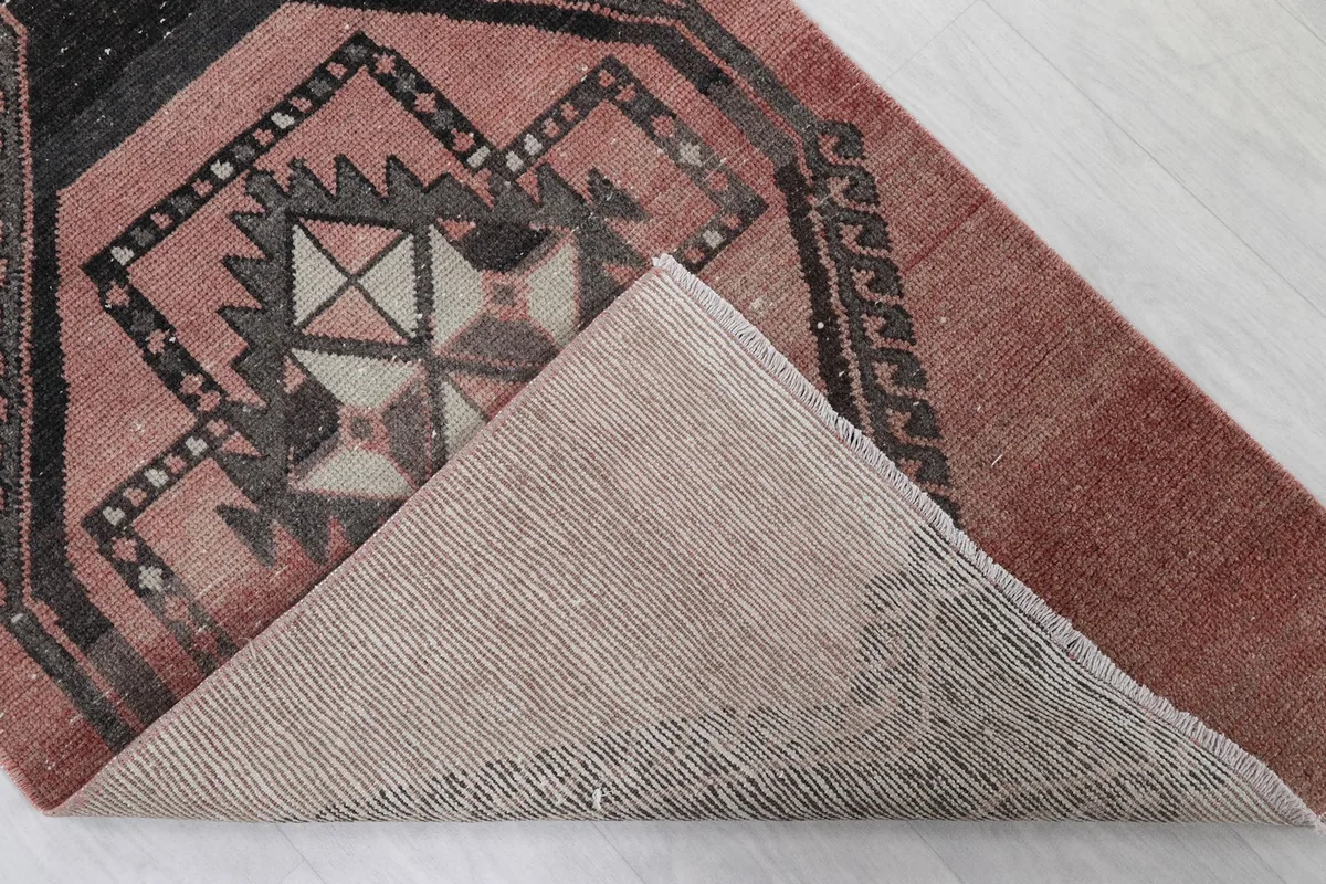 Underside view of a corner of the rug, revealing the cotton foundation and hand-knotted structure.