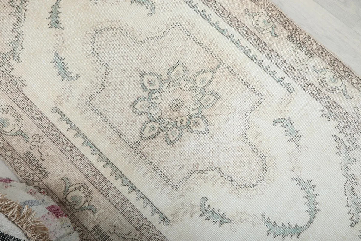 Angled view highlighting the rug's ivory field and blue floral designs