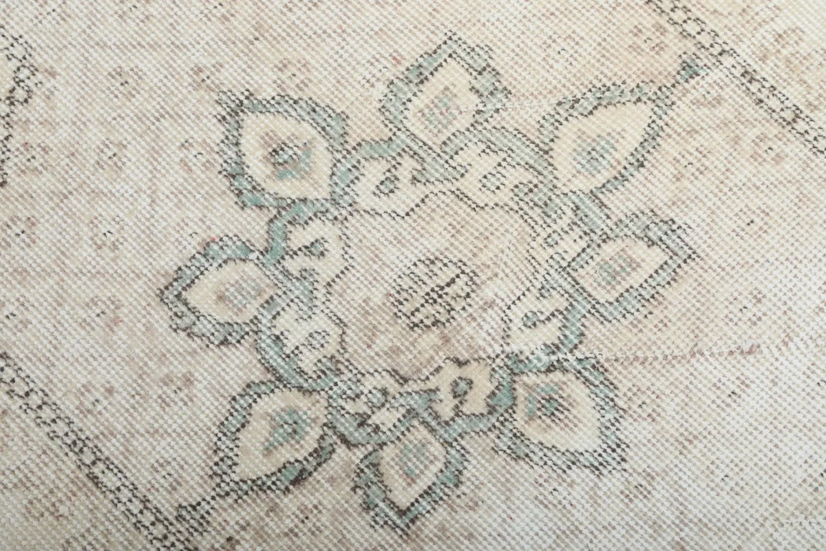 Detailed close-up of the central floral medallion with blue and beige tones