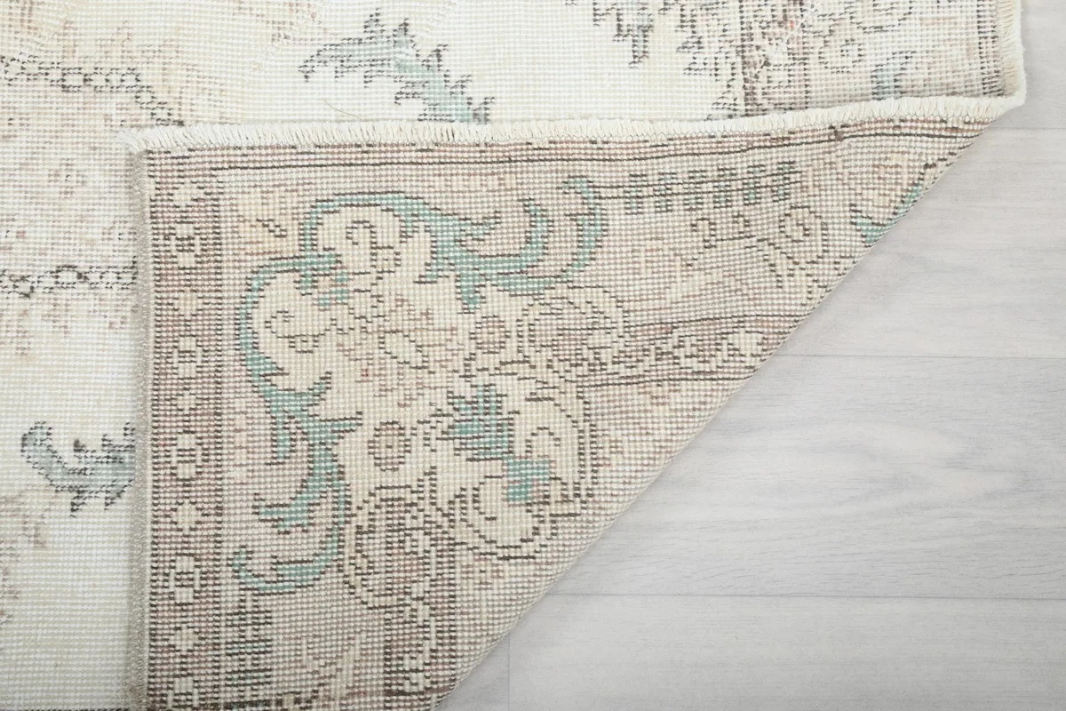 Another view of the rug corner folded, revealing the reverse side
