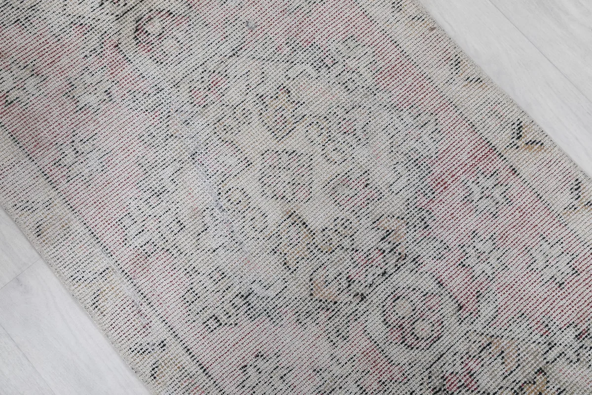 Close-up of the central medallion and faded rose tones in the rug's pile