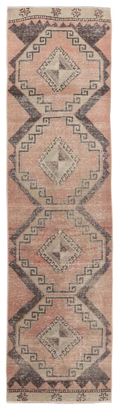 Full overhead view of a vintage rose and charcoal geometric Anatolian runner rug.