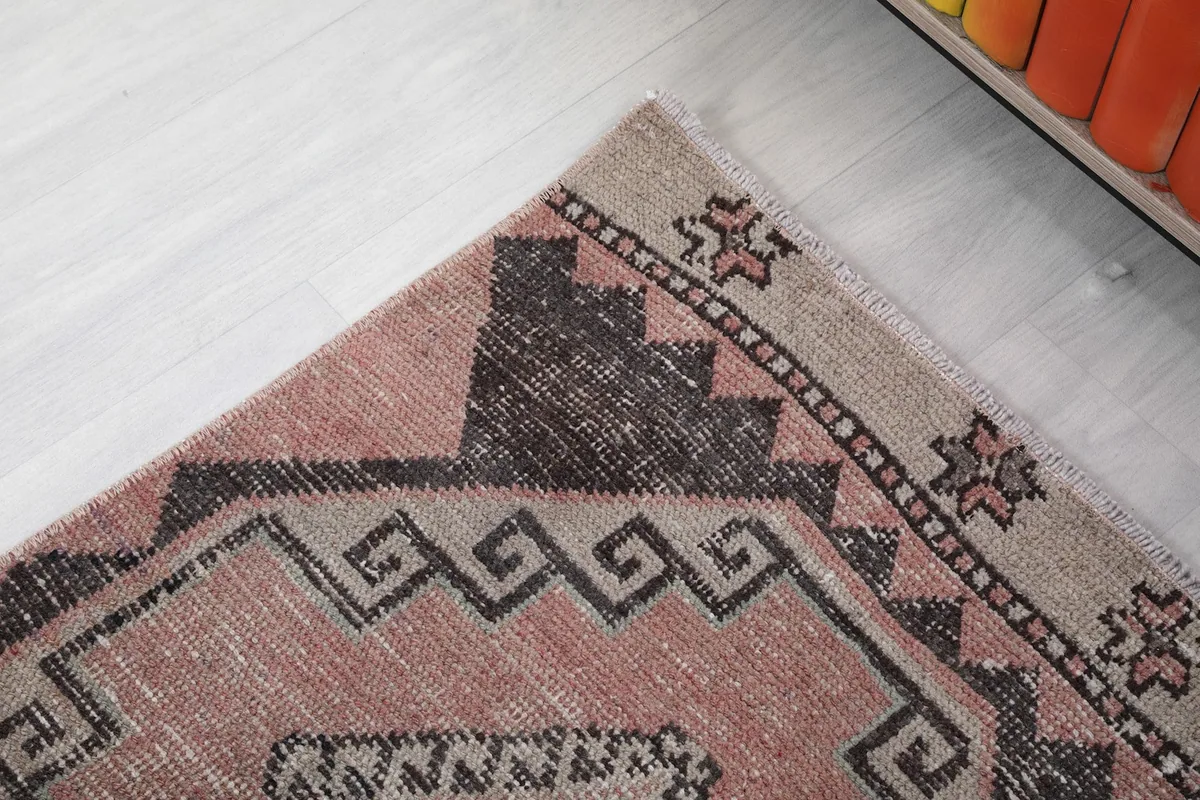 Detail of the rug's border and corner, highlighting the subtle edge patterns and fringe.