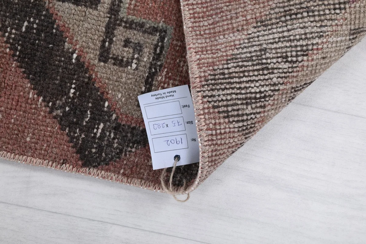 Close-up of the rug's corner with a product tag displaying measurements.