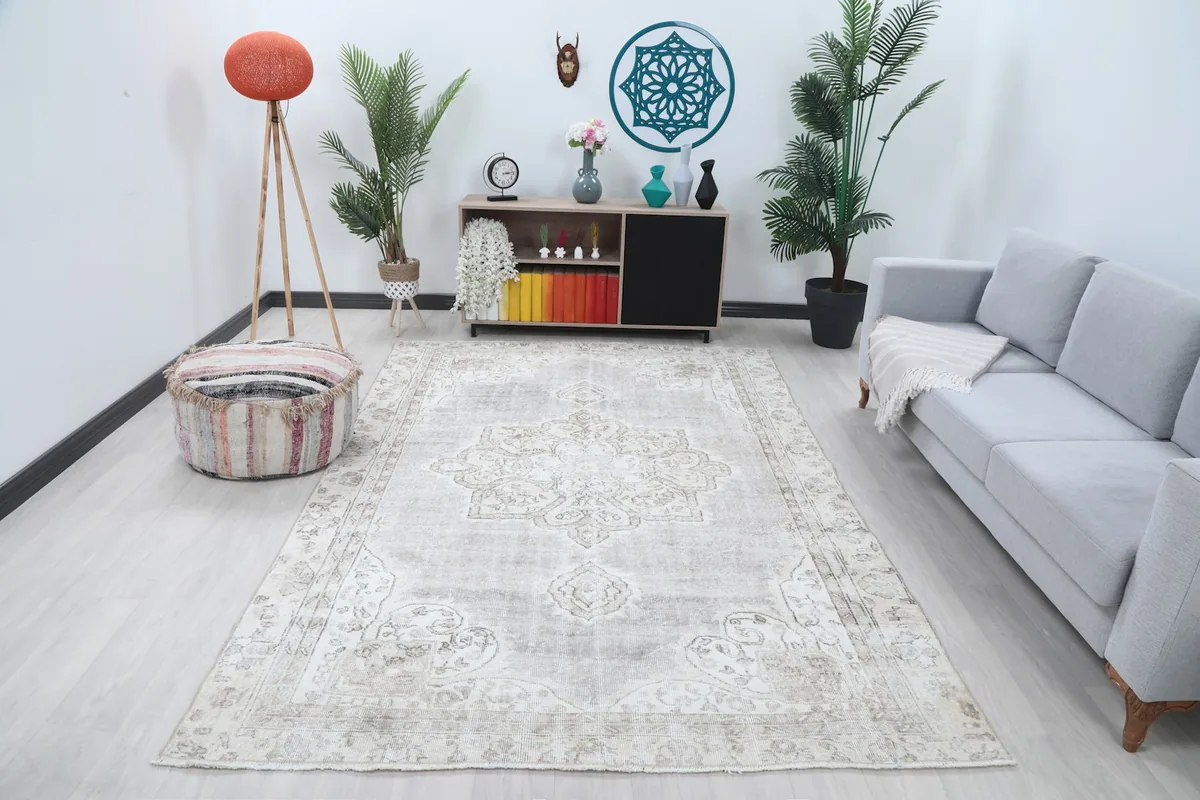 Vintage gray and ivory rug placed in a living room setting with a light-colored sofa