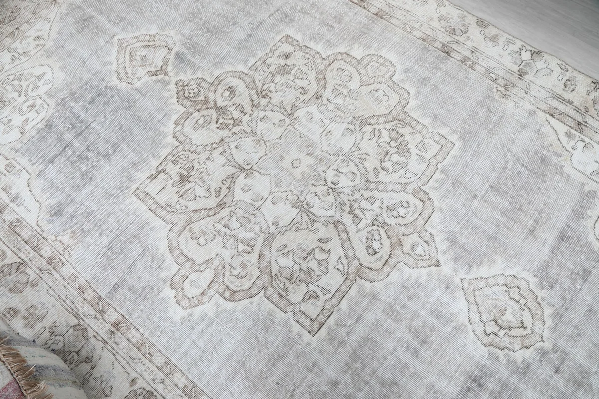 Detailed view of the central medallion motif and subtle color variations in the gray rug