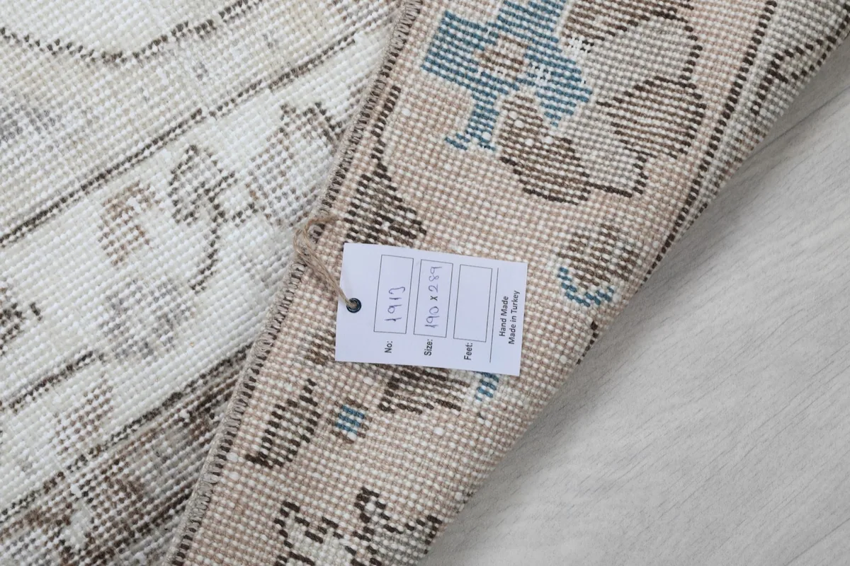 Detail of the rug's back with a tag, showing the tight knotting and yarn colors