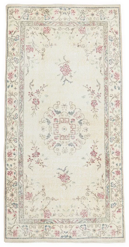 Full top view of the ivory floral medallion vintage Anatolian rug on a white background
